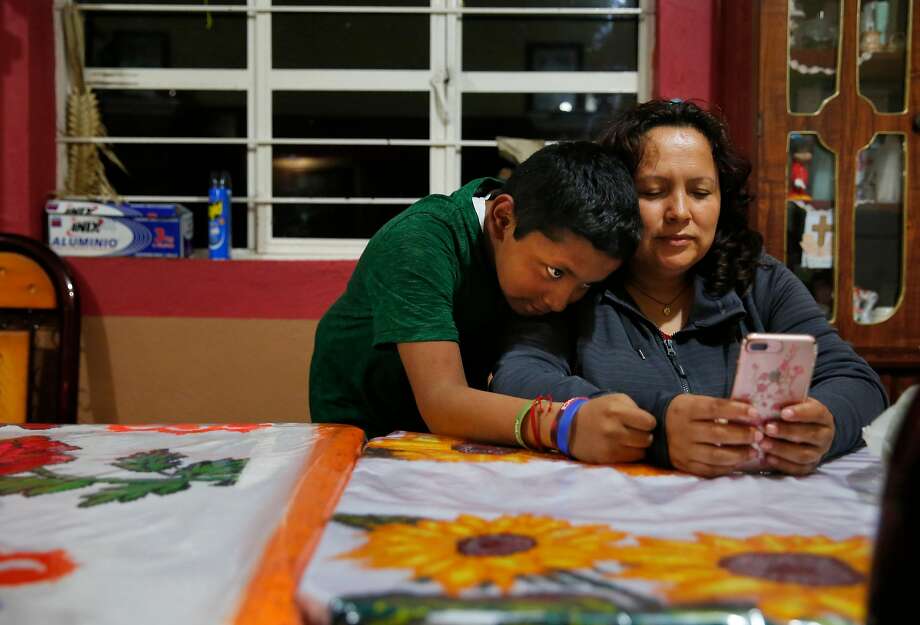 Jesus Sanchez, 12, leans on his mother Maria Mendoza-Sanchez as they video chat with his sisters back in Oakland Sept. 27, 2017 in Santa Monica, Hidalgo, Mexico. Photo: Leah Millis, The Chronicle
