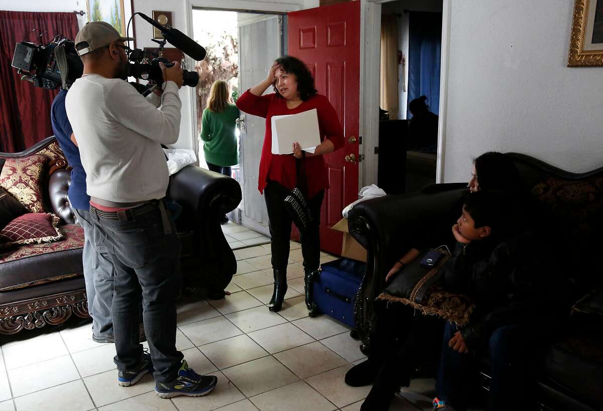 Maria Mendoza-Sanchez announces to a gaggle of media in her home that she, her husband and their son were able to delay their flight to Mexico for a day after they spent the morning believing they were leaving immediately.