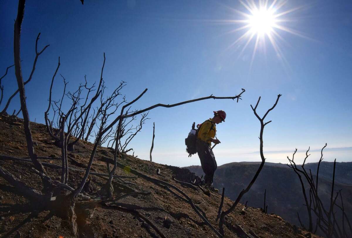In the Thomas Fire zone, Santa Barbara County Fire Capt. Ryan Thomas hikes down steep terrain to meet with his crew and root out and extinguish smoldering hot spots in Santa Barbara.