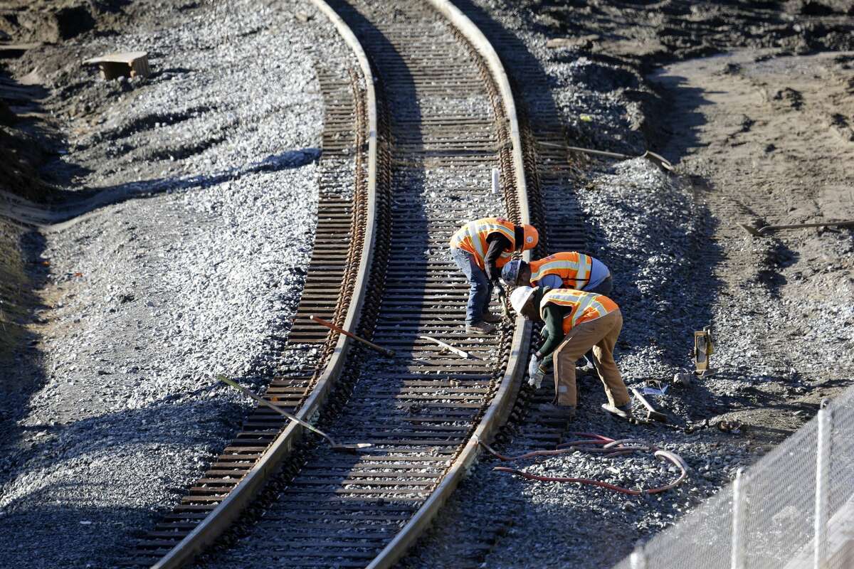 People work at the curve where an Amtrak train derailed onto Interstate 5 two days earlier Wednesday, Dec. 20, 2017, in DuPont, Wash. The Amtrak train that careened off the overpass south of Seattle, killing at least three people, was hurtling 50 mph over the speed limit when it jumped the track, federal investigators say, when it derailed along a curve, spilling railcars onto the highway below. (AP Photo/Elaine Thompson)