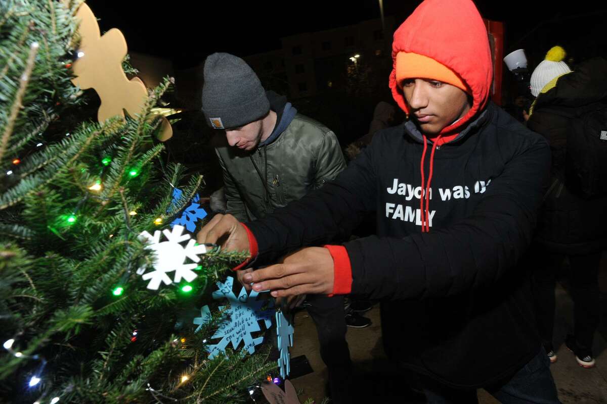 Jovon Mercado, of Bridgeport, helps decorate a Christmas tree set up near the spot on Fairfield Ave. where Negron was shot a killed by Bridgeport Police last May, seen here Dec. 20, 2017.