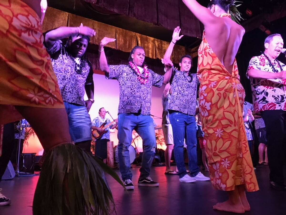 University of Houston players participate in a hula demonstration during Wednesday night’s Hawaii Bowl luau. Houston will face Fresno State in the Hawaii Bowl Sunday night.