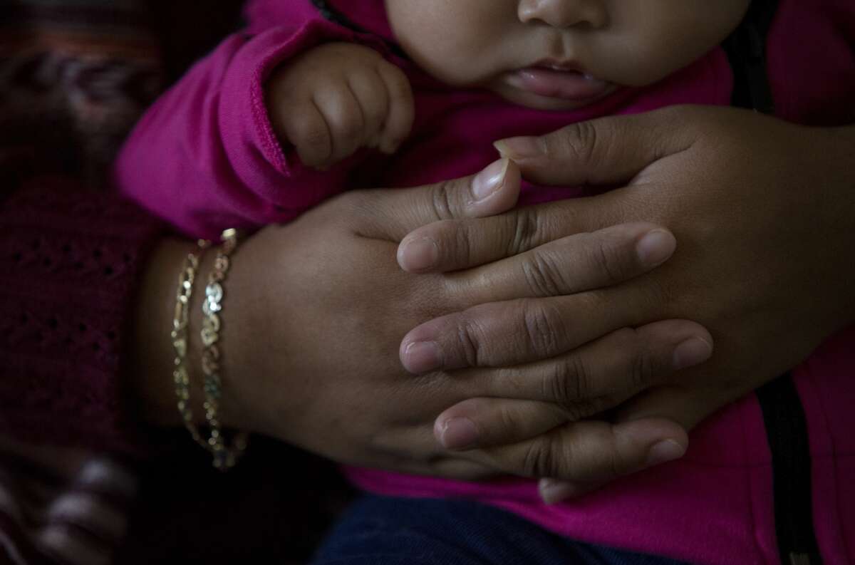 Lorena, 26, holds her four-month-old daughter after she woke up from a nap , in Northwest Houston.