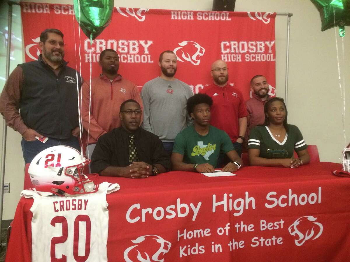 Crosby senior Craig Williams with his parents, coaches, and Crosby ISD superintendent Keith Moore at a celebration at Crosby High School on Dec. 21 for his signing his National Letter of Intent to play college football at Baylor University