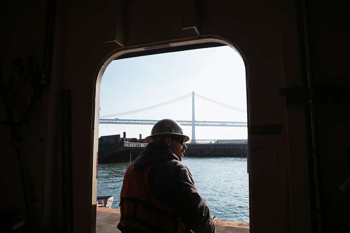 Heath Lassiter walks through a door on the floating crane as construction continues on the expansion of the ferry terminal in San Francisco, Calif. Wednesday, December 13, 2017.