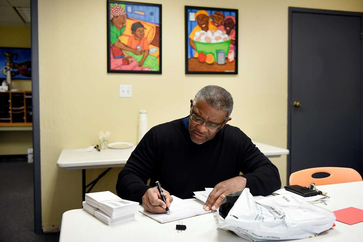 Director Joe Wilson, signs payroll checks for his employees at the Hospitality House, a homeless outreach non-profit that recently celebrated it's 50th year of operation, in San Francisco, Calif., on Wednesday December 13, 2017.