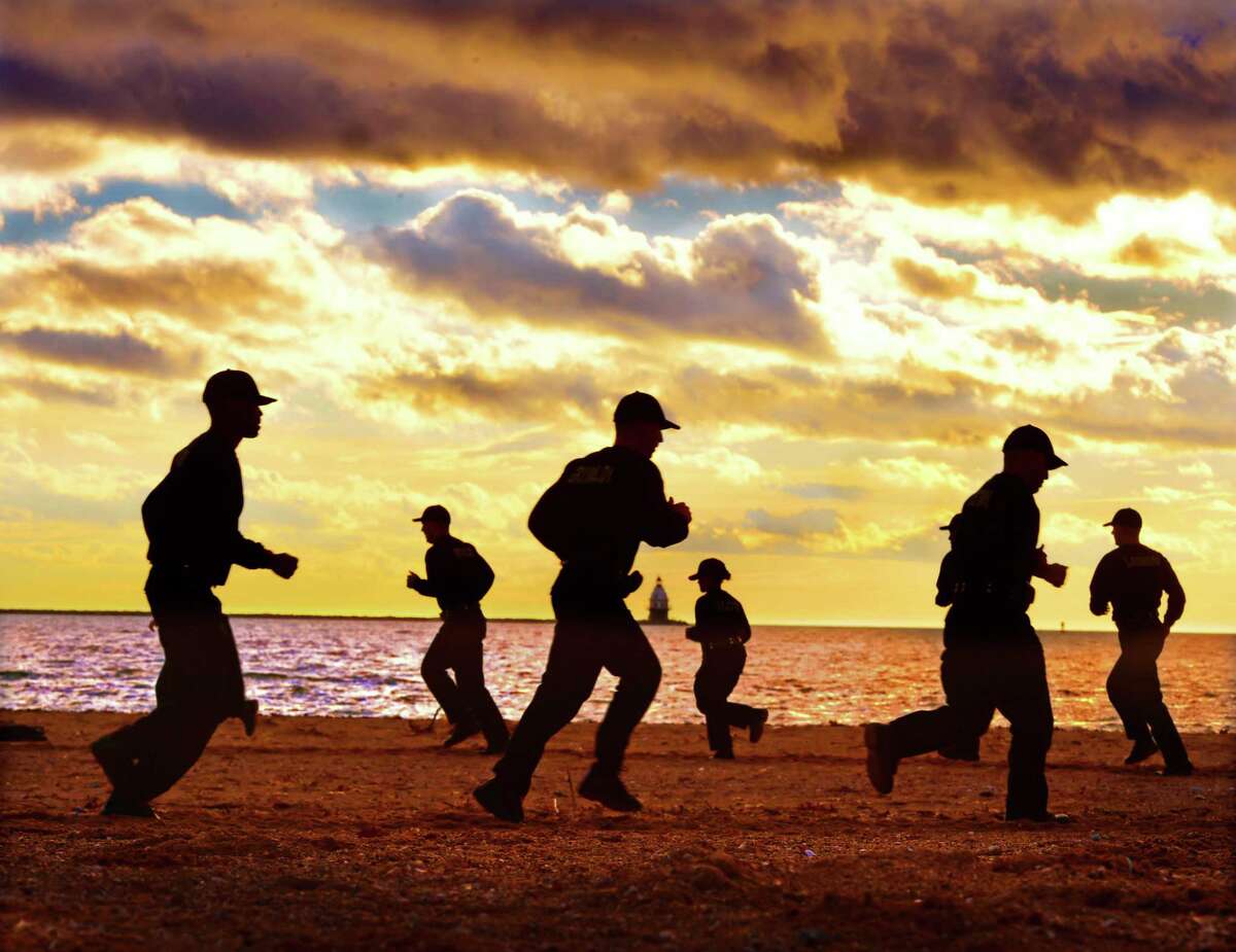 (Peter Hvizdak - New Haven Register) After a day of classroom work, the New Haven Police Academy Recruits of Class 22 run through a motivational physical fitness training exercise late Wednesday afternoon, January 4, 2017 at Lighthouse Point Park. The class consists of 28 New Haven Police recruits 2 Trumbull Police recruits.