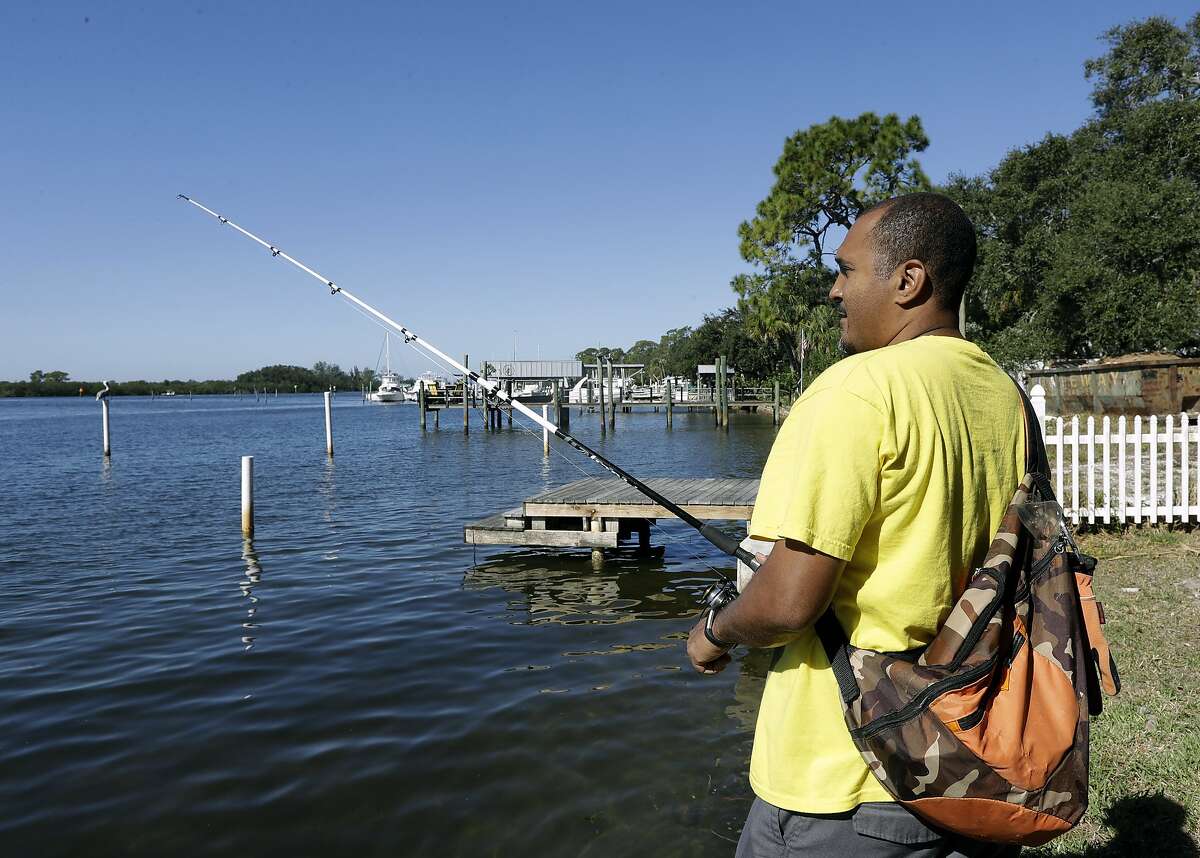 In this Nov. 30, 2017 photo, Anthony Stansbury fishes in the Anclote River in Tarpon Springs, Fla. When Stansbury moved down the street from the Anclote River in Florida last year, he didn�t know his slice of paradise had a hidden problem. The neighborhood is adjacent to the Stauffer Chemical Co. Superfund site, a former chemical manufacturing plant on the list of the nation�s most polluted places. (AP Photo/Chris O'Meara)