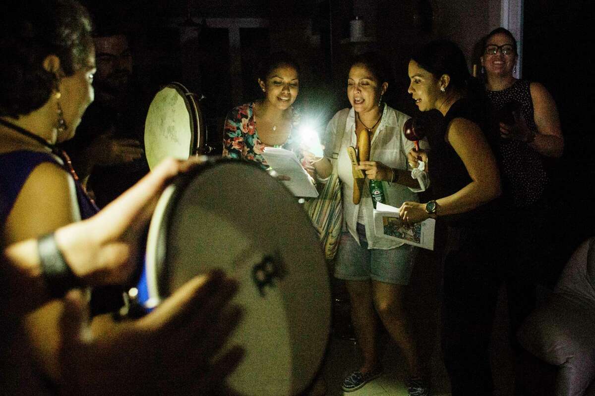 By the light of their cellphones, people gather for a parranda, a Puerto Rican Christmas tradition that brings friends together to sing carols, usually in the ﻿night, in Guayabo, Puerto Rico.