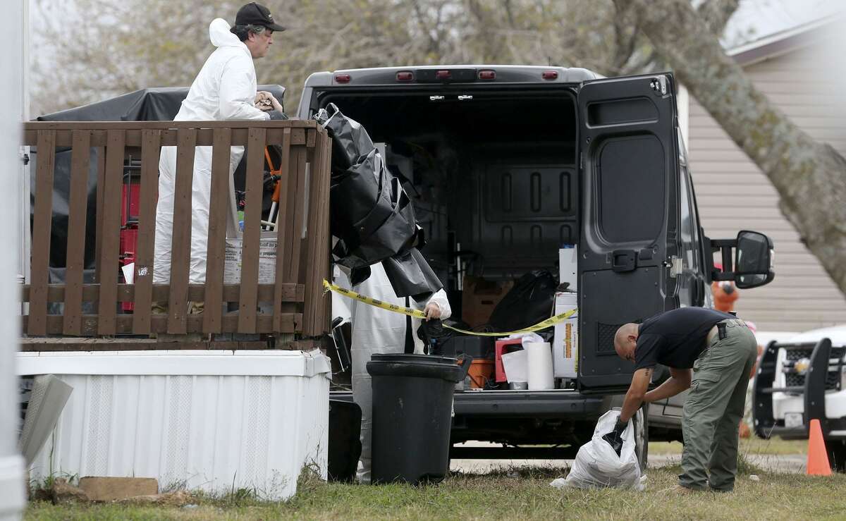 A county detective (right) looks through a garbage bag Friday December 22, 2017 at a manufactured home on the 100 block of Peach Lane in the Pecan Grove Maufactured Home Community in Schertz, Texas where six-year-old Kameron Prescott was shot. Prescott was shot while inside his home in the 100 block of Peach Lane. Four Bexar County deputies had been chasing a wanted felon in the area, and they opened fire on her as she tried to break into Prescott's home. The woman, who has not been identified, was killed.