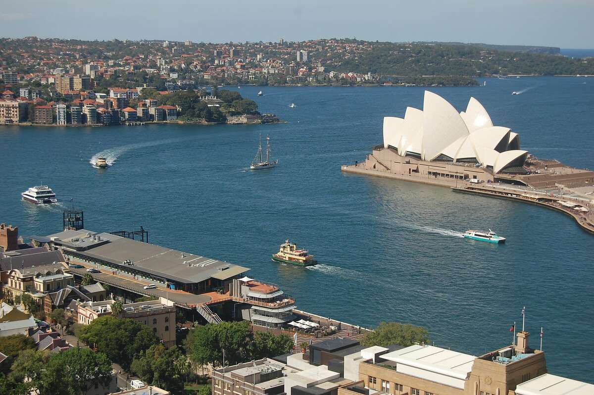 With its sail-inspired tile roofs, the iconic Sydney Opera House stands as the center of bustling Sydney Harbour.