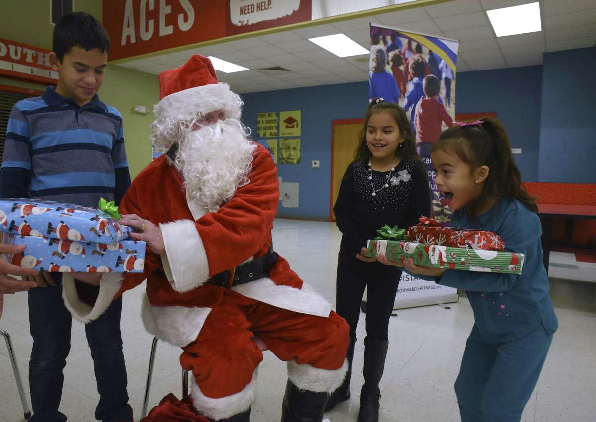 Aliah Davis, right, jumps for joy after receiving Christmas gifts from Santa Claus, who is played by Bexar County Sheriff’s Office assistant chief Bobby Hogeland, during an event at the Southside Independent School District on Saturday, Dec. 23, 2017. Hogeland resigned from the sheriff’s office Thursday to pursue other opportunities.