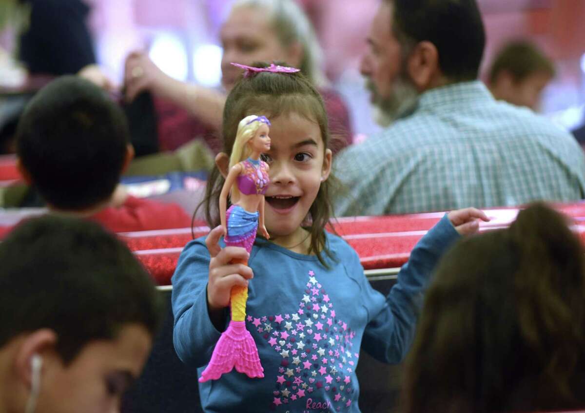 Aliah Davis, 6, is thrilled after opening her Christmas gift at the Southside Independent School District on Saturday, Dec. 23, 2017. Southside children and their families received a tamales lunch and gifts from Santa Claus through a program put on by San Antonio philanthropist Kym Rapier.