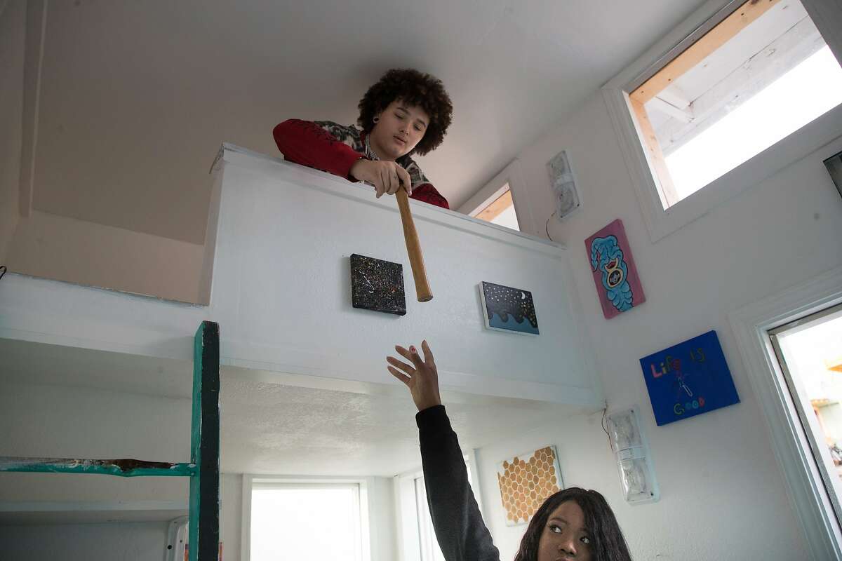 2017年12月22日，星期五，加州伯克利，16岁的斯托米·亚当斯(Stormy Adams)在卧室的阁楼里递给玛梅·迪亚拉·阿卜杜勒-拉赫曼work一把锤子。他们希望在一个村庄里为无家可归的年轻人建造25座微型房屋。