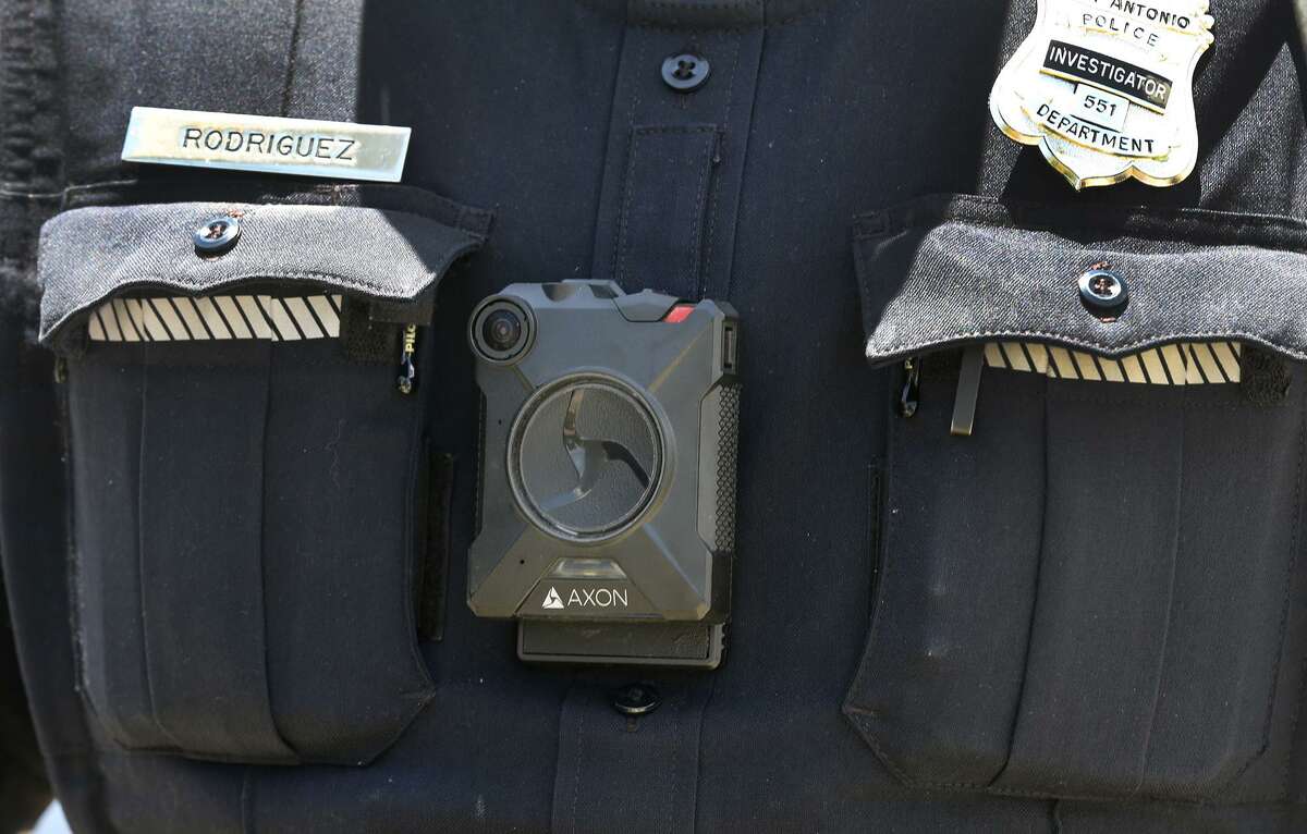 An officer with a body camera investigates Thursday June 23, 2016 on the 2100 block of Burnet where two people were shot near the Walters Food Mart. Police received reports of the shooting around 12:45 p.m. at the intersection of North Walters and Burnet Streets and arrived at the parking lot of the Walter's Food Mart within seconds, according San Antonio Police Department Chief William McManus. At this point the victims are not cooperating with police. One of the victims was taken to the San Antonio Medical Center and the other was taken to University Hospital for treatment. Officers said one of them was shot in the hip and the other in the leg.