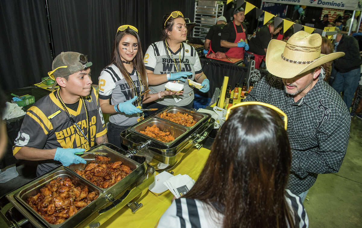 The team at the Buffalo Wild Wings booth serves samples of barbecue and mild wings on Thursday, February 2, 2017 during the WBCA Taste of Laredo at the Laredo Energy Arena.