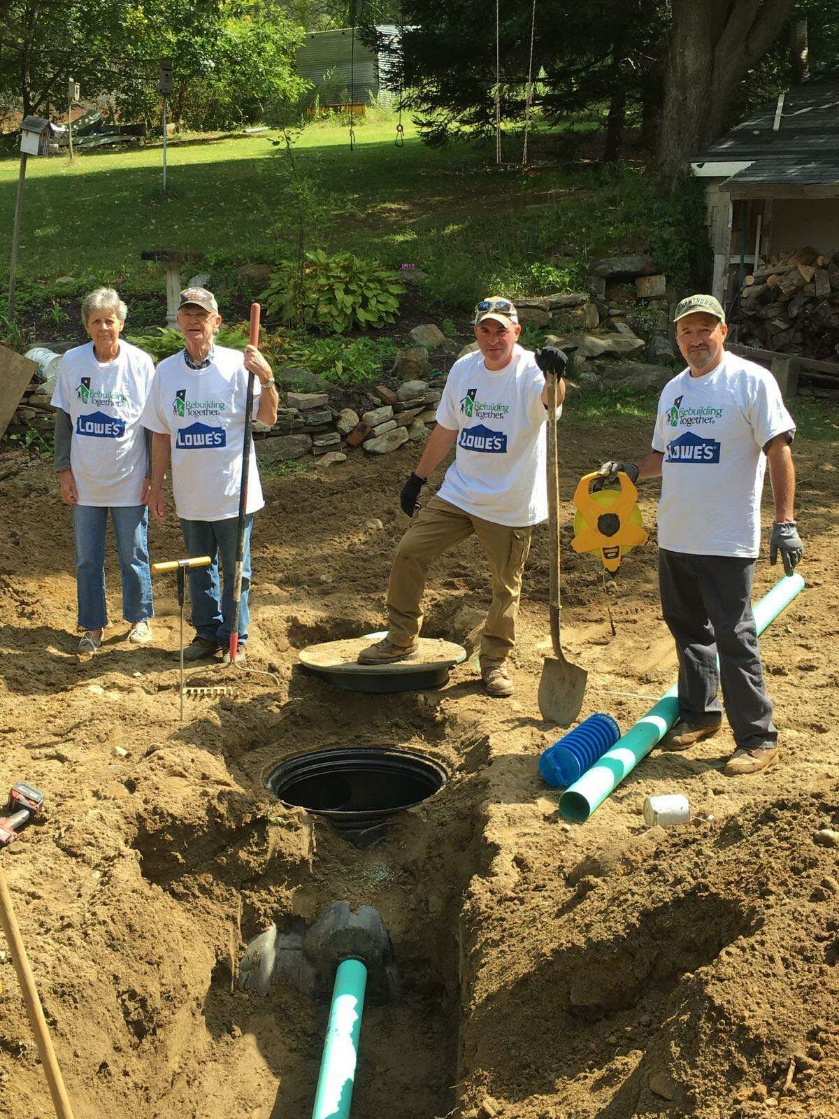Lowe's Home Improvement recently partnered with Rebuilding Together Litchfield County and New Milford Septic to replace a septic system for a New Preston veteran. Volunteers are shown above working on the project.