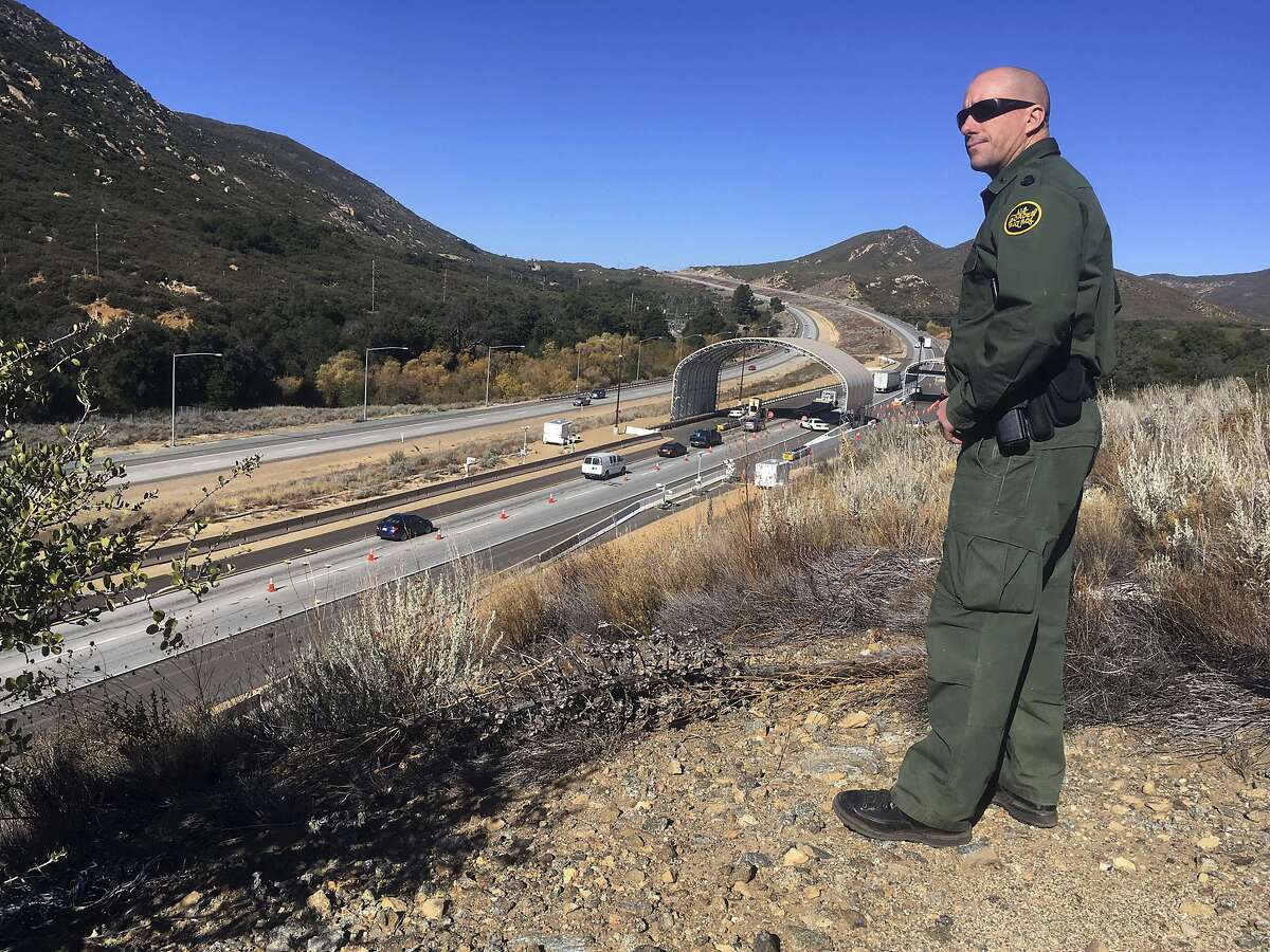 CORRECTS PHOTOGRAPHER NAME TO ELLIOT FROM ELLIOTT - In this Thursday, Dec. 14, 2017 photo, Border Patrol agent Troy Hunt looks over California's Pine Valley checkpoint, on the main route from Arizona to San Diego. California legalizes marijuana for recreational use Jan. 1 but that won't stop federal agents from seizing small amounts on busy freeways and backcountry highways. Possession will still be prohibited at eight Border Patrol checkpoints in California, a daily demonstration of state and federal law colliding. (AP Photo/Elliot Spagat)