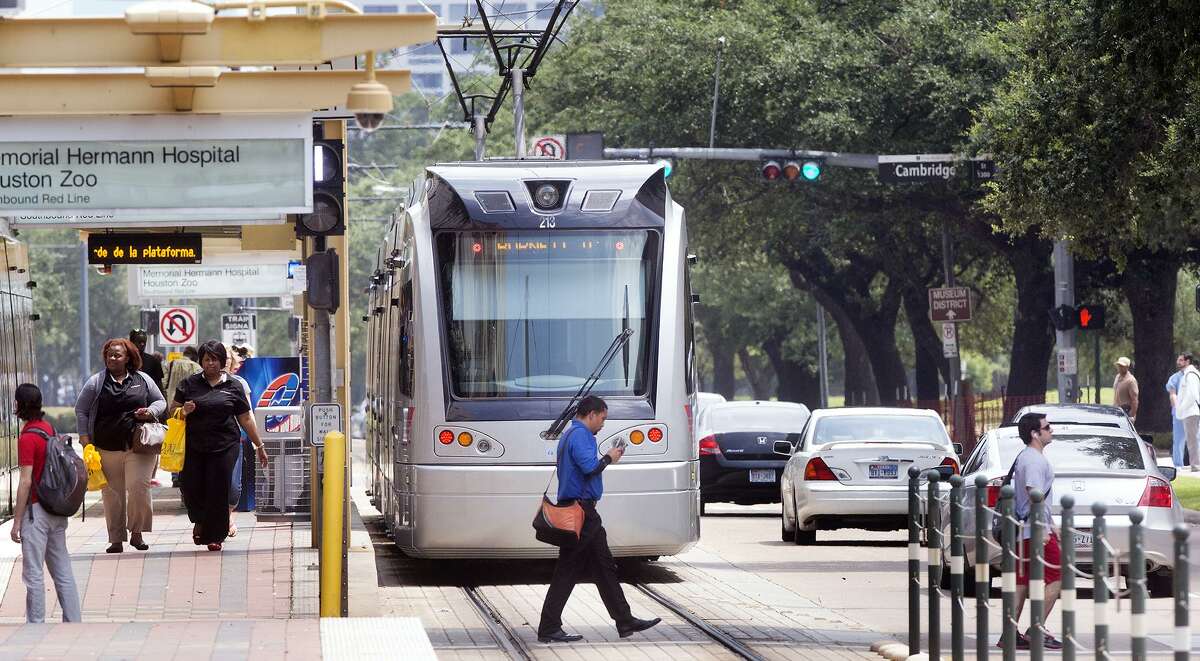 A METRO rail makes its way along the track as a group of pedestrians cross Fannin Street in the Medical Center, Thursday, July 24, 2014, in Houston. (Cody Duty / Houston Chronicle)