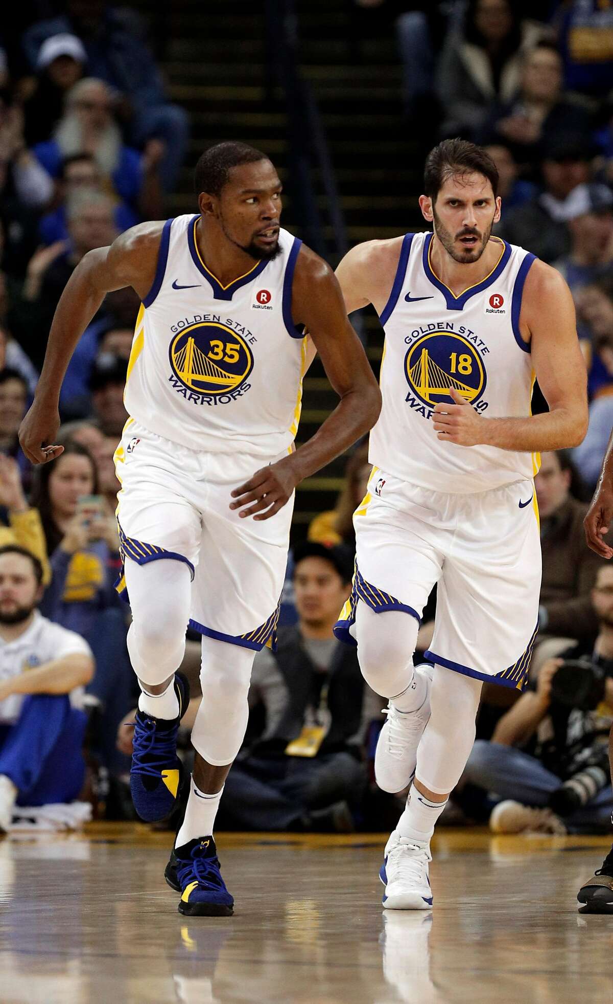 Kevin Durant (35) and Omri Casspi (18) head back up court after Casspi scored in the first half as the Golden State Warriors played the Utah Jazz at Oracle Arena in Oakland, Calif., on Wednesday, December 27, 2017.