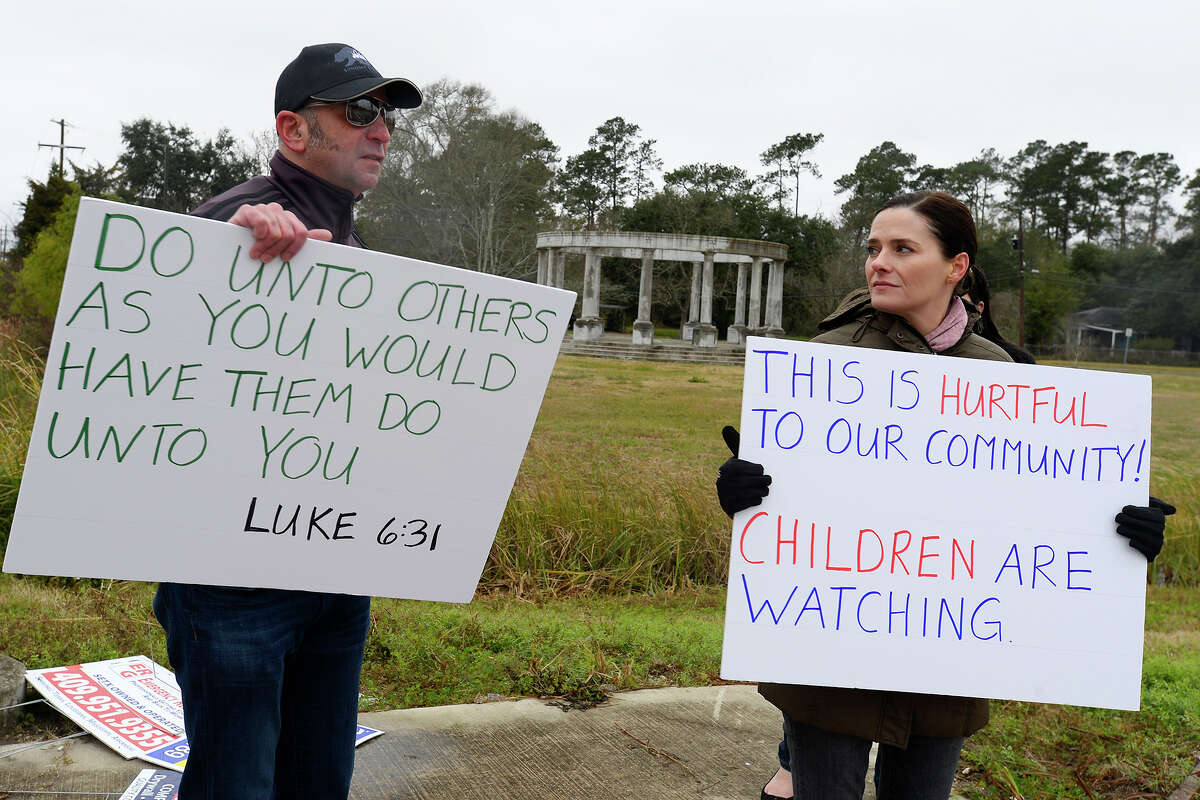 Jeremy and Tracie Parzen hold protest signs near the Confederate Memorial of the Wind in Orange on Wednesday. The unfinished memorial is being built by the Sons of Confederate Veterans next to Interstate 10. Photo taken Wednesday 12/27/17 Ryan Pelham/The Enterprise