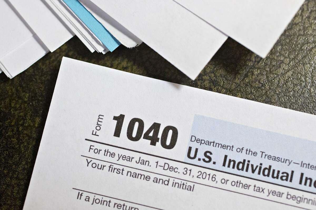U.S. Department of the Treasury Internal Revenue Service (IRS) 1040 Individual Income Tax forms for the 2016 tax year are arranged for a photograph in Tiskilwa, Illinois, U.S., on Monday, Dec. 18, 2017. This week marks the last leg of Republicans' push to revamp the U.S. tax code, with both the�House�and Senate planning to vote by Wednesday on final legislation before sending it to President�Donald Trump. Photographer: Daniel Acker/Bloomberg