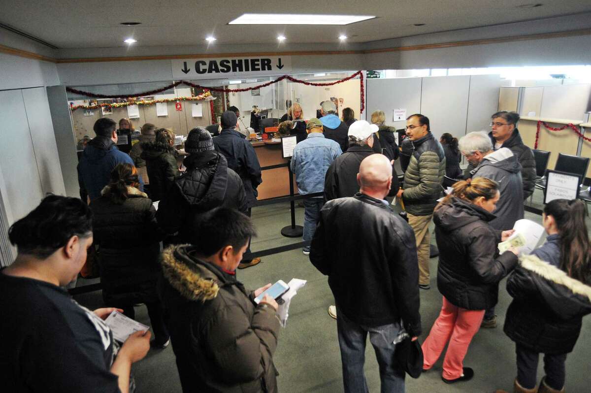 Residents stand in line to pay their tax bills before Jan. 1 on the sixth floor of Stamford Government Center in downtown Stamford, Conn. on Thursday, Dec. 28, 2017.