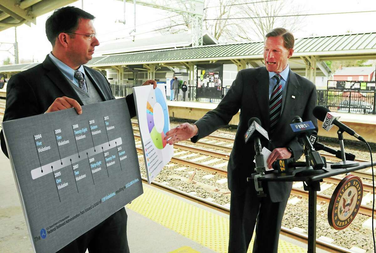 (Peter Hvizdak - New Haven Register) ¬ Milford Mayor Ben Blake, left, holds visual aids as U.S. Senator Richard Blumenthal (D-Conn) holds a press conference at the Milford Train Station Friday April, 18, 2014 about data on Metro-North Safetyfines ring back over a decade, what he intends to do to tighten safety standards for the railroad and how those standards will be used as a model for the country's railroads.