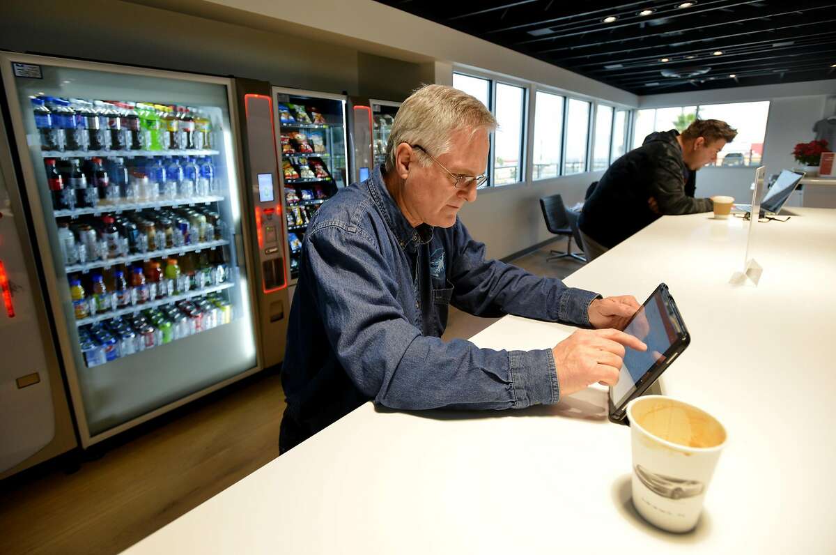 David Schultz, 63, of Newberry Park, enjoys a cup of coffee while working on his tablet inside the customer lounge during a stop to charge his Tesla on Friday, December 15, 2017 at the Tesla Supercharger station along I-5 in Kettleman City, Calif. Schultz makes this trip to visit his 96-year-old mother in San Francisco at least once a month. The Tesla Supercharger station has 40 Superchargers available exclusively for Tesla owners, a 24/7 customer lounge, restrooms, free WiFi, a coffee bar, vending machines, a children's play area and an outdoor pet run.