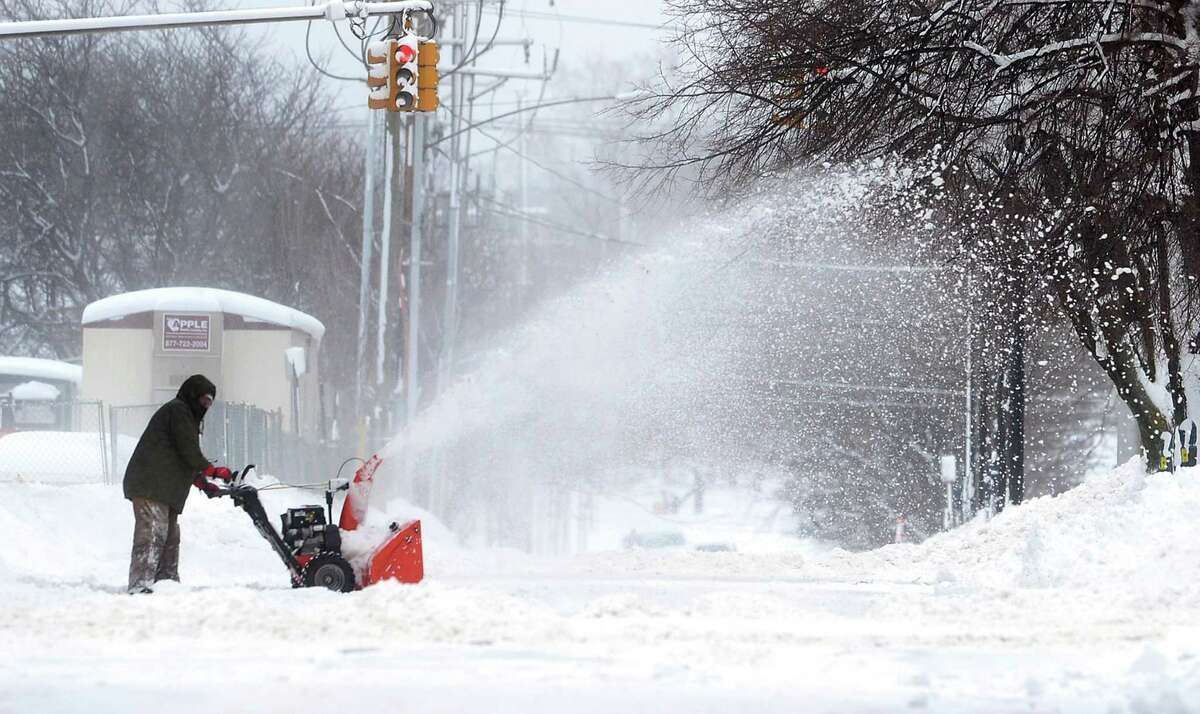 A man clears snow on Tuesday, Dec. 26, 2017, in Erie, Pa. The National Weather Service office in Cleveland says Monday's storm brought 34 inches of snow, an all-time daily snowfall record for Erie. (Greg Wohlford/Erie Times-News via AP)