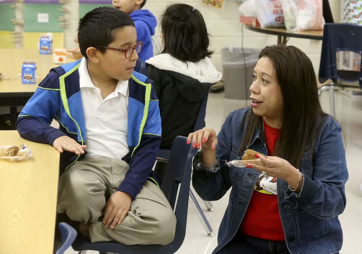 Student Nathaniel Hernandez,8, (left) has breakfast Wednesday morning December 20, 2017 with second grade teacher Patricia Tristan (right) in her classroom at De Zavala Elementary school on San Antonio's West Side. The San Antonio Independent School District is ranked highly statewide for its school food program, mostly due to serving breakfast in class which drives student participation rates higher.