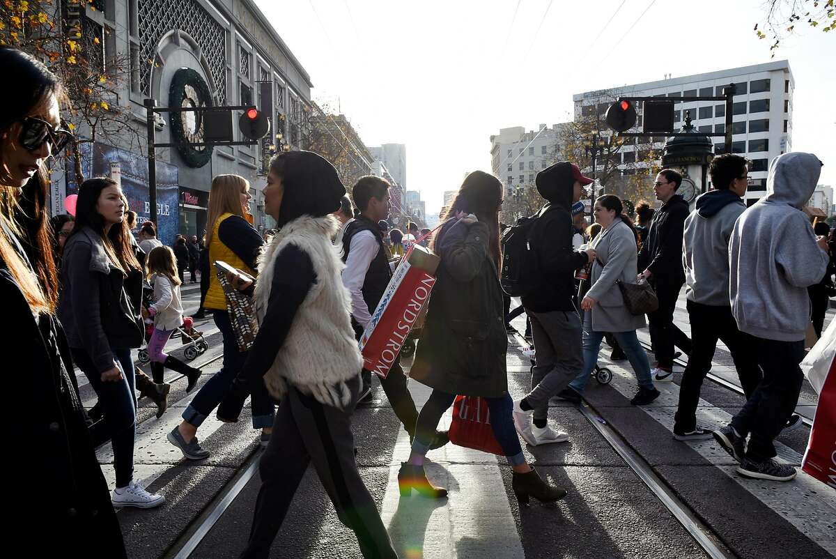 Pedestrians cross Market Street in San Francisco on December 28, 2017.