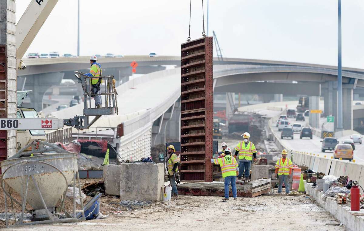 Workers remove a form from a new sign post during construction on Highway 290 on Thursday, December 21, 2017 in Houston Texas.