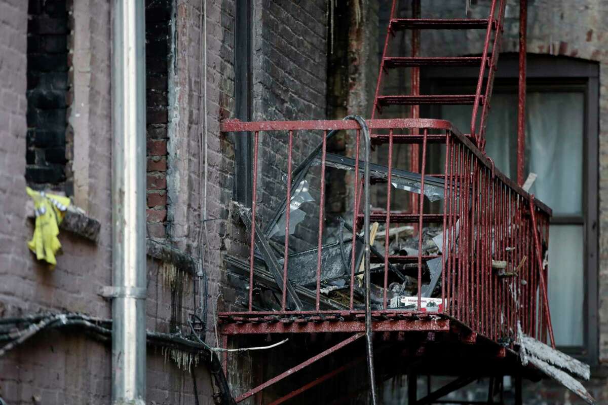 Charred items sit on the fire escape of an apartment building where more than 10 people died in fire a day earlier in the Bronx borough of New York, Friday, Dec. 29, 2017. New York City's deadliest residential fire in decades was accidentally lit by a boy playing with the burners on his mother's stove, officials said Friday. (AP Photo/Julio Cortez)