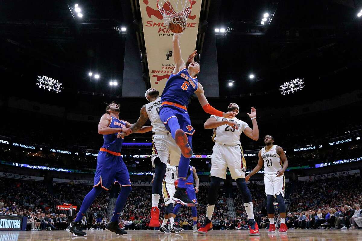 New York Knicks forward Kristaps Porzingis (6) dunks over New Orleans Pelicans forward Anthony Davis (23) and center DeMarcus Cousins (0) during the second half of an NBA basketball game in New Orleans, Saturday, Dec. 30, 2017. The Knicks won 105-103. (AP Photo/Jonathan Bachman)