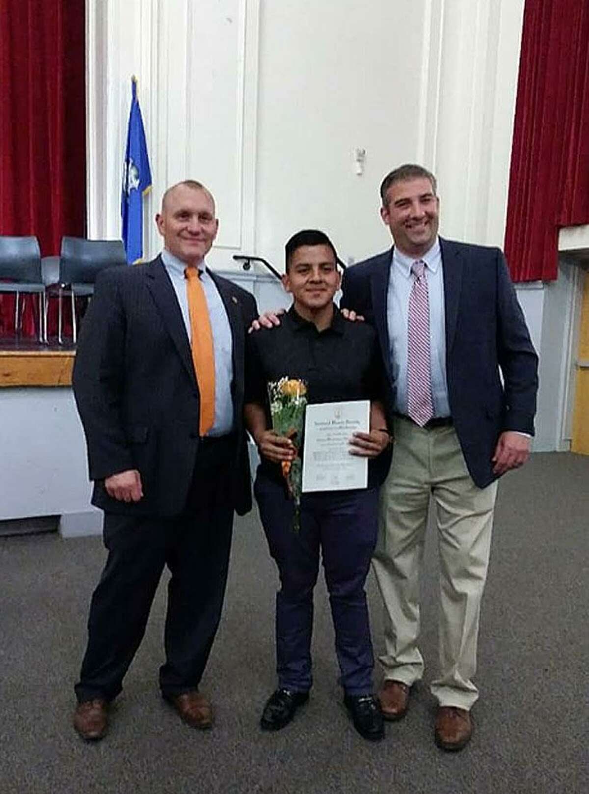 Erwin Hernandez, center, is recognized by Stamford High Principal Ray Manka, left, and Assistant Principal Matt Forker after being inducted into the National Honor Society. Hernandez had his leg amputated after an accident last week.