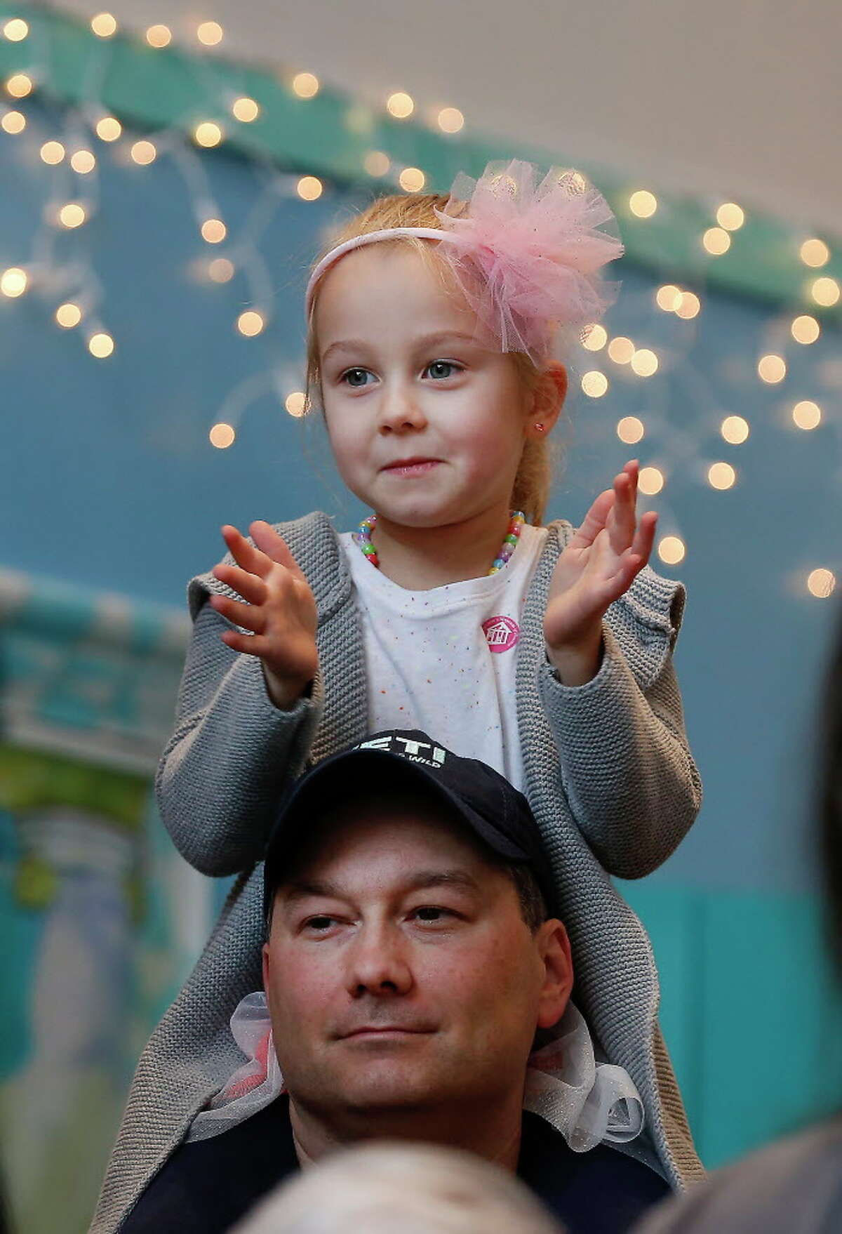 Elizabeth Baudin, 4, enjoys the view from her father's, Brandon, shoulders during The Children's Museum of Houston's Rockin' New Year's Noon Bash Sunday, Dec. 31, 2017, in Houston. The event is the city's longest-running New Year's Eve celebration just for kids. This end-of-year bash rings in the New Year at the stroke of noon with a parade and shimmering ball drop.
