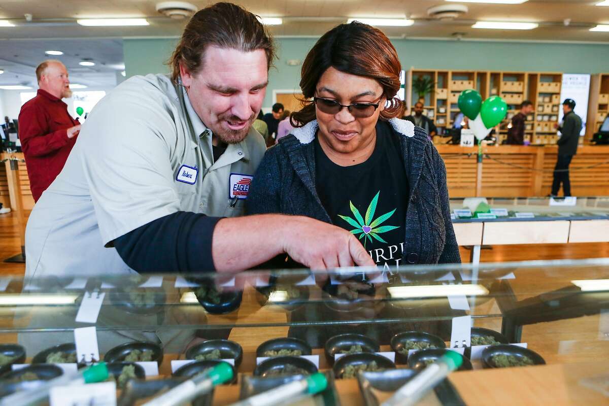 Customers Robert Thompson and Ranita Reed look over a selection of marjiuana products at Harborside Health Center on the first day of recreational marijuana sales in California on Monday, January 1, 2018 in Oakland, California.