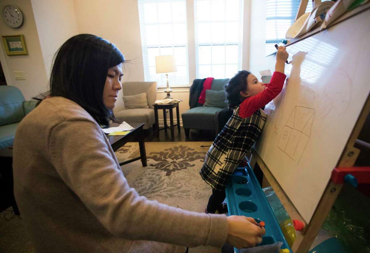 Two-and-a-half-year-old Eliana Yang draws a sun next after asking her mother Susan Yang, left, to help her draw their home, Sunday, Dec. 31, 2017, in Houston, which is under repairs after it got flooded during Hurricane Harvey. Susan's resolution for the New Year is to return to normalcy in their home. Susan says her daughter often expresses feelings of nostalgia about their home. ( Marie D. De Jesus / Houston Chronicle )