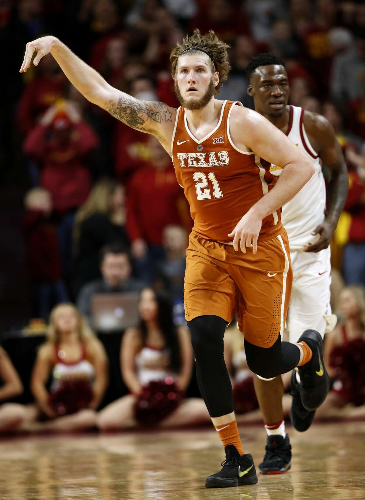 Texas forward Dylan Osetkowski (21) celebrates in front of Iowa State forward Cameron Lard, right, after making 3-point basket at the end of an NCAA college basketball game, Monday, Jan. 1, 2018, in Ames, Iowa. Osetkowski scored 25 points as Texas won 74-70 in overtime. (AP Photo/Charlie Neibergall)