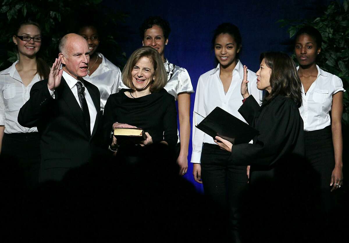 SACRAMENTO, CA - JANUARY 03: Jerry Brown (L) is sworn in as the 39th governor of California by California Chief Justice Tani Cantil-Sakauye (R) as Brown's wife, Anne Gust-Brown (C), looks on January 3, 2011 in Sacramento, California. Jerry Brown will begin his third term as California's governor 28 years after serving his last term.