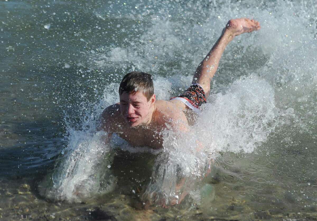 Greenwich's J.P. Ohl, 14, faceplants into the water during the annual New Years Day Dip Polar Plunge for Kids in Crisis at Greenwich Point Park in Old Greenwich, Conn. Monday, Jan. 1, 2018. Although the event was officially canceled due to extremely cold weather, dozens of participants still plunged into the frigid waters to benefit Kids in Crisis.