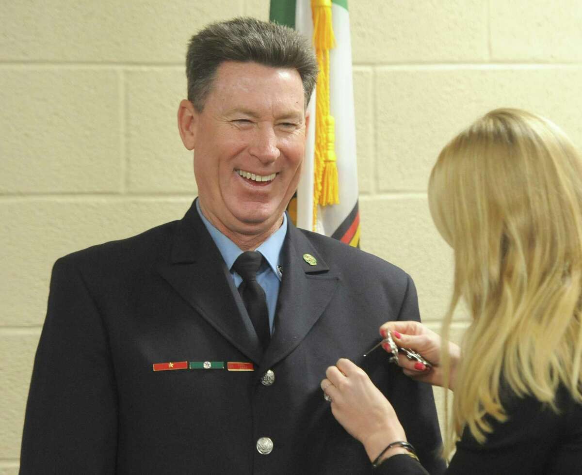 John Kiernan has his badge pinned on by his daughter, Kara Kiernan, during his swearing-in ceremony as new Fire Marshal at the Public Safety Complex in Greenwich, Conn. Tuesday, Jan. 2, 2018.