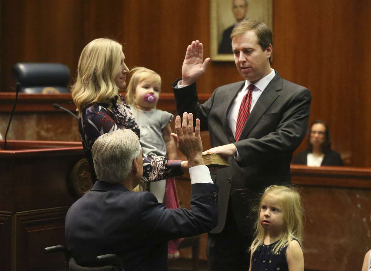 Texas Gov. Greg Abbott (left, facing away) administers the oath of office to James Davis Blacklock (right) on Tuesday at the Supreme Court of Texas in Austin. Blacklock, accompanied by his family, became a justice of the Supreme Court of Texas.