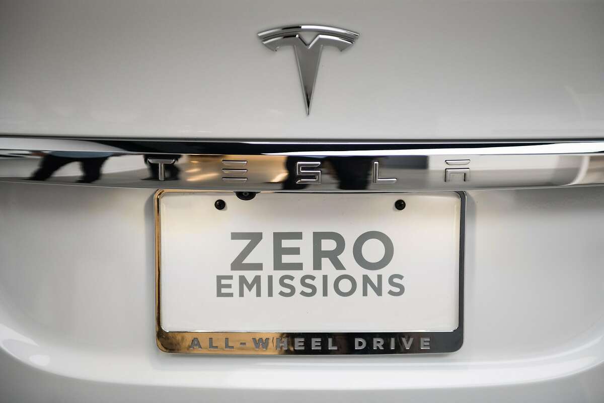 A "Zero Emissions" tag is seen on the rear of a Tesla Inc. Model X P100D sports utility vehicle (SUV) at the company's new showroom in New York, U.S., on Thursday, Dec. 14, 2017. The Meatpacking District location, which opens to the public at 11 a.m. Friday, lets customers for the first time explore energy offerings, configure cars and place orders all under one roof. Photographer: Mark Kauzlarich/Bloomberg