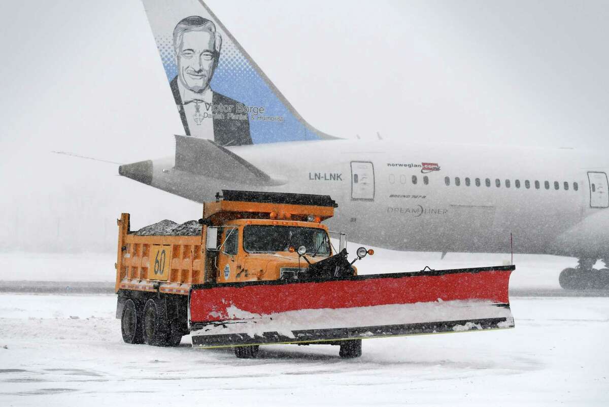 Snow is cleared to make a parking spot for a Norwegian Air Boeing 787-9 Dreamliner that was diverted from JFK to Albany International Airport because of bad weather on Thursday, Jan. 4, 2018, in Colonie, N.Y. The flight originated at London Gatwick. (Will Waldron/Times Union)