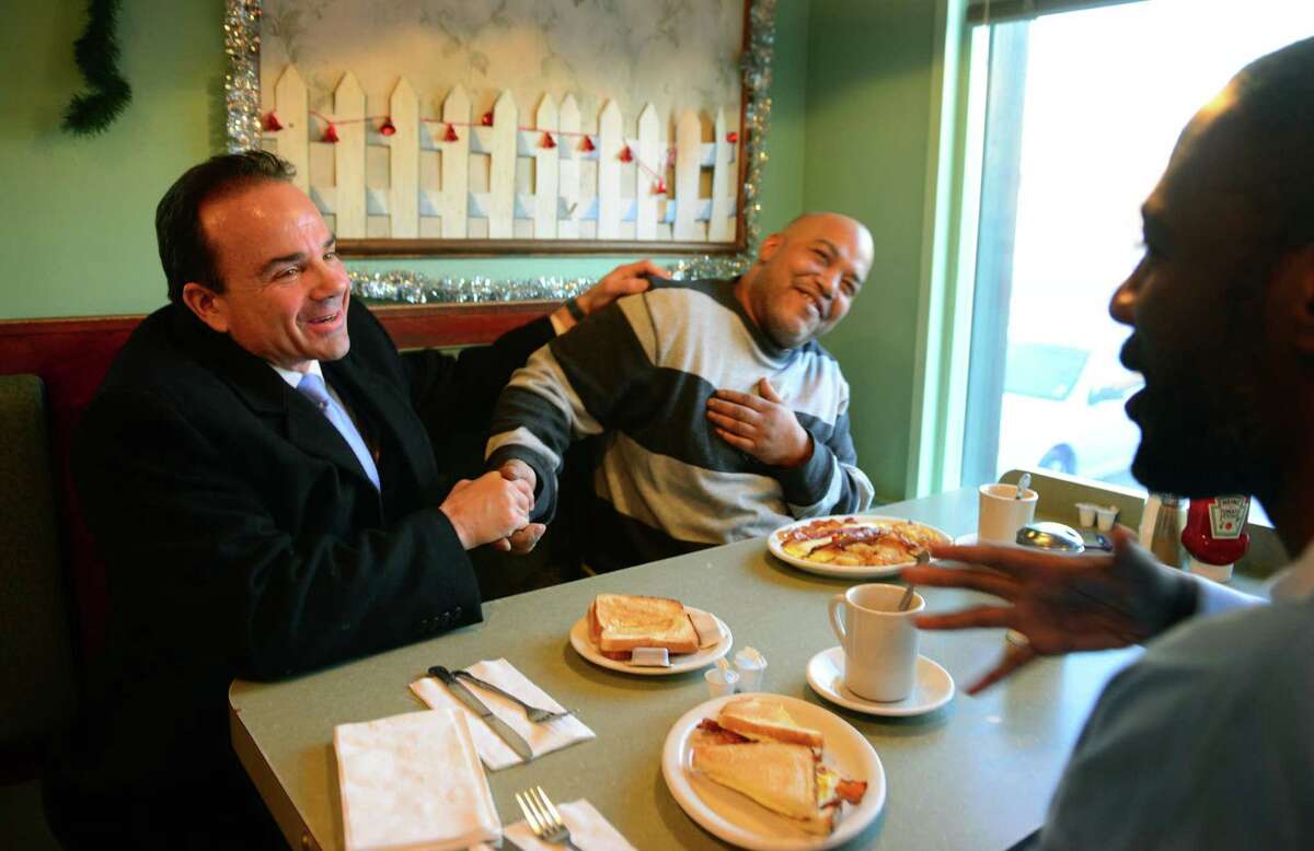 Mayor Joe Ganim, left, greets Terrance Martin, center, and Demetrius Thomas, right, during a stop at Frankies Diner in Bridgeport, Conn. on Thursday July 6, 2017. Mayor Ganim announced today that his is running for governor.