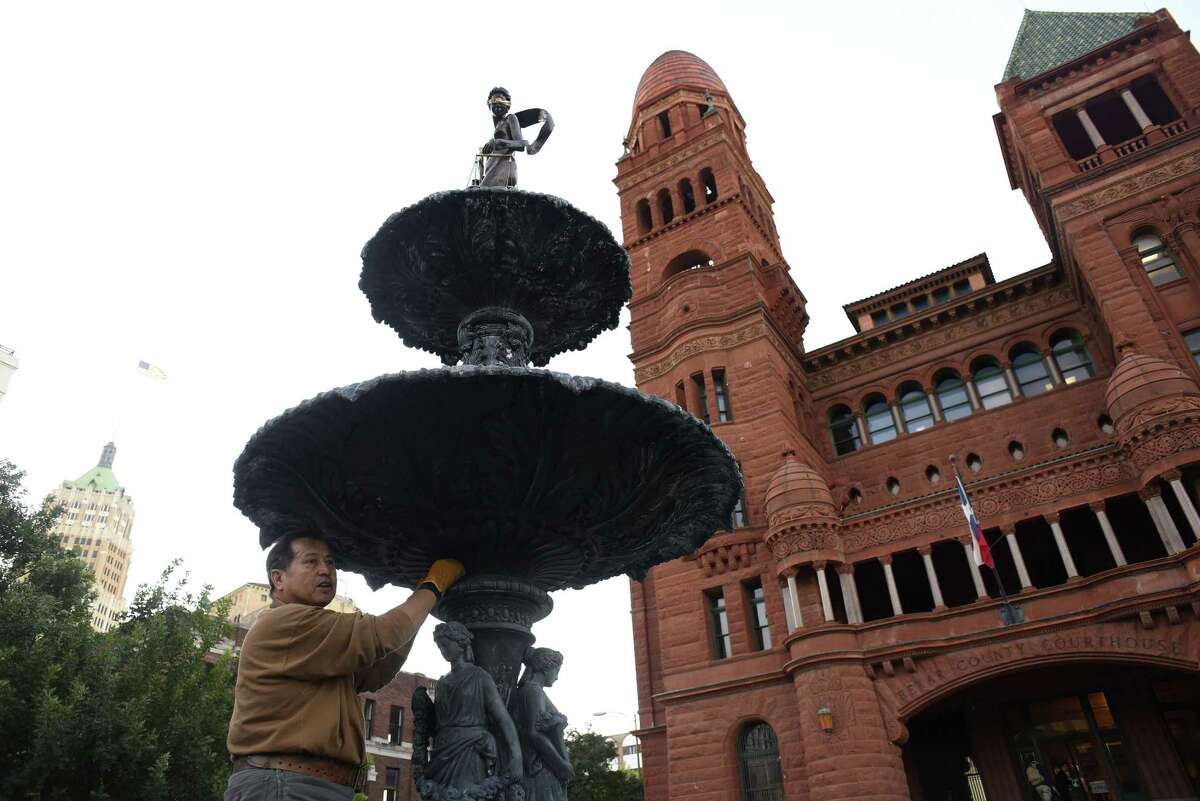 Gilbert E. Barrera uses steel wool on the 121-year-old fountain in front of the old Bexar County Courthouse, where he is refurbishing the fountain and the statue of Lady Justice, which he created and stands atop the fountain on Tuesday, Oct. 17, 2017.