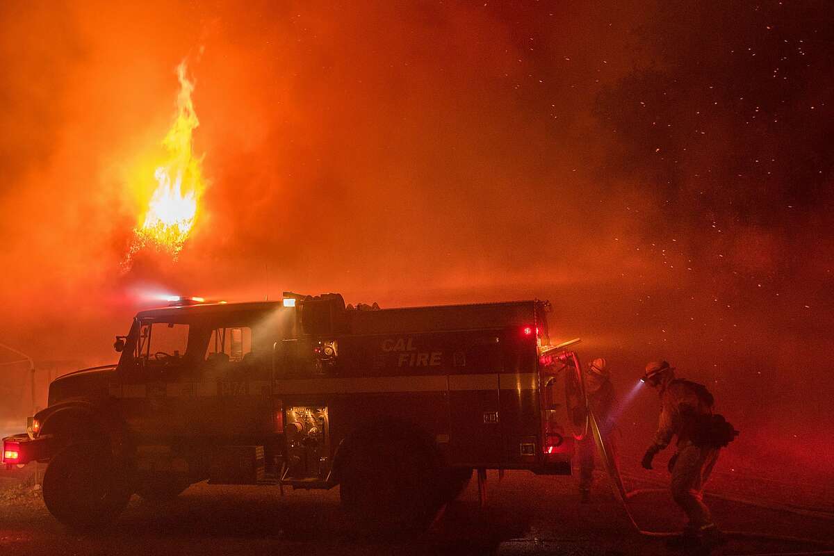 Firefighters work to save structures on Soda Canyon Road in Napa, Calif., on Monday, Oct. 9, 2017.
