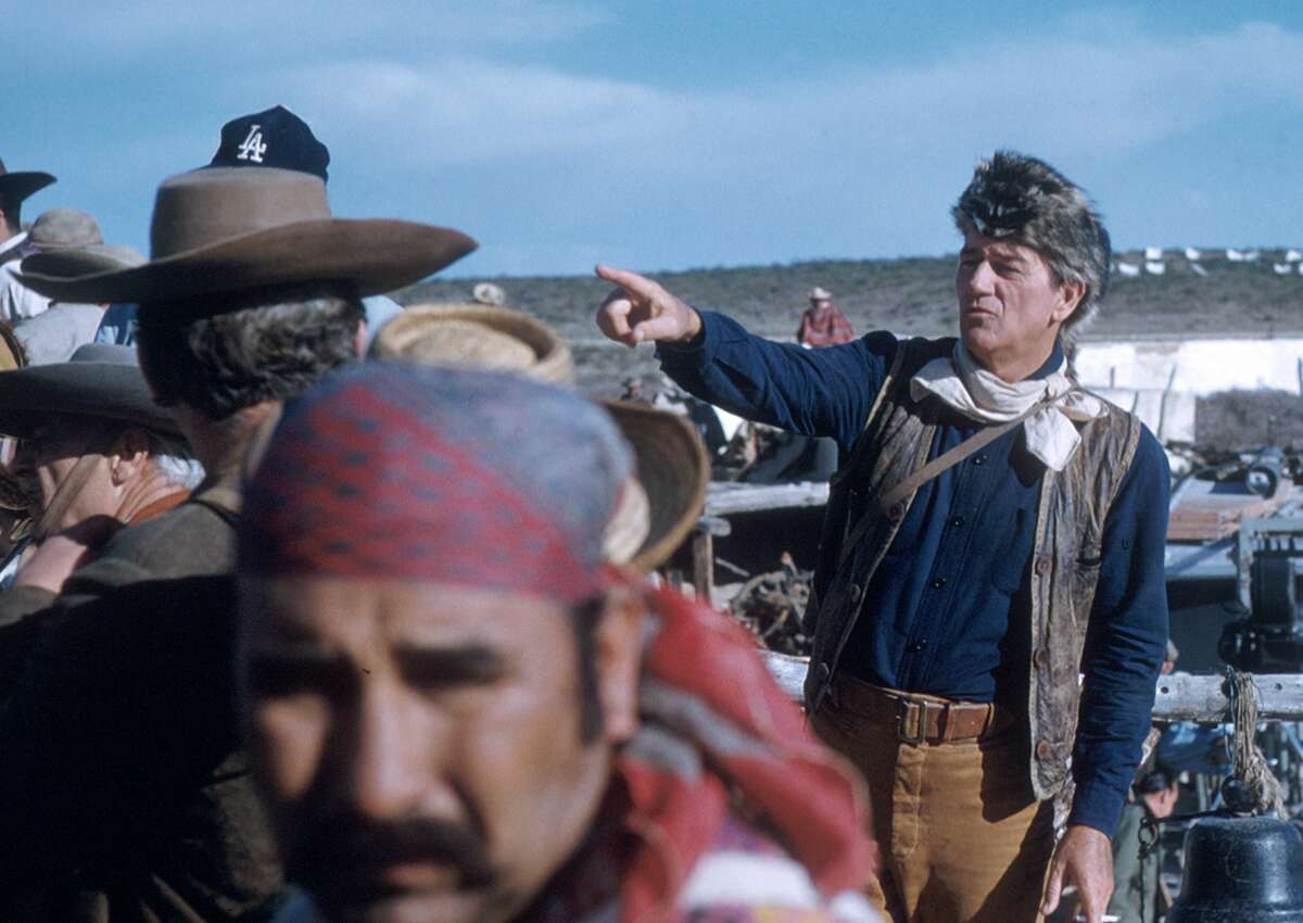 In costume (as Colonel Davy Crockett), American actor John Wayne (1907 - 1979) (right) directs crew members in the scene from his film 'The Alamo', Brackettville, Texas, 1960. (Photo by Tom Nebbia/Corbis via Getty Images)